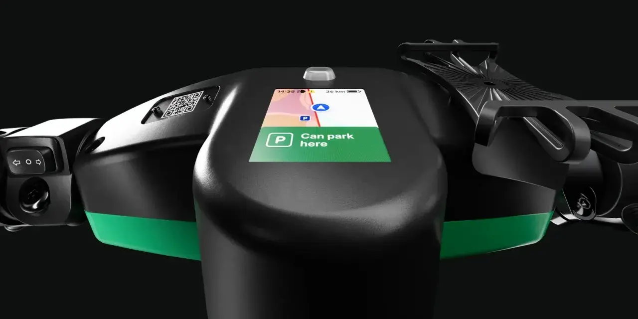Lenkrad eines E-Scooters mit Display, das die Bolt Taxi App anzeigt. "Can park here" ist auf dem Bildschirm zu lesen.