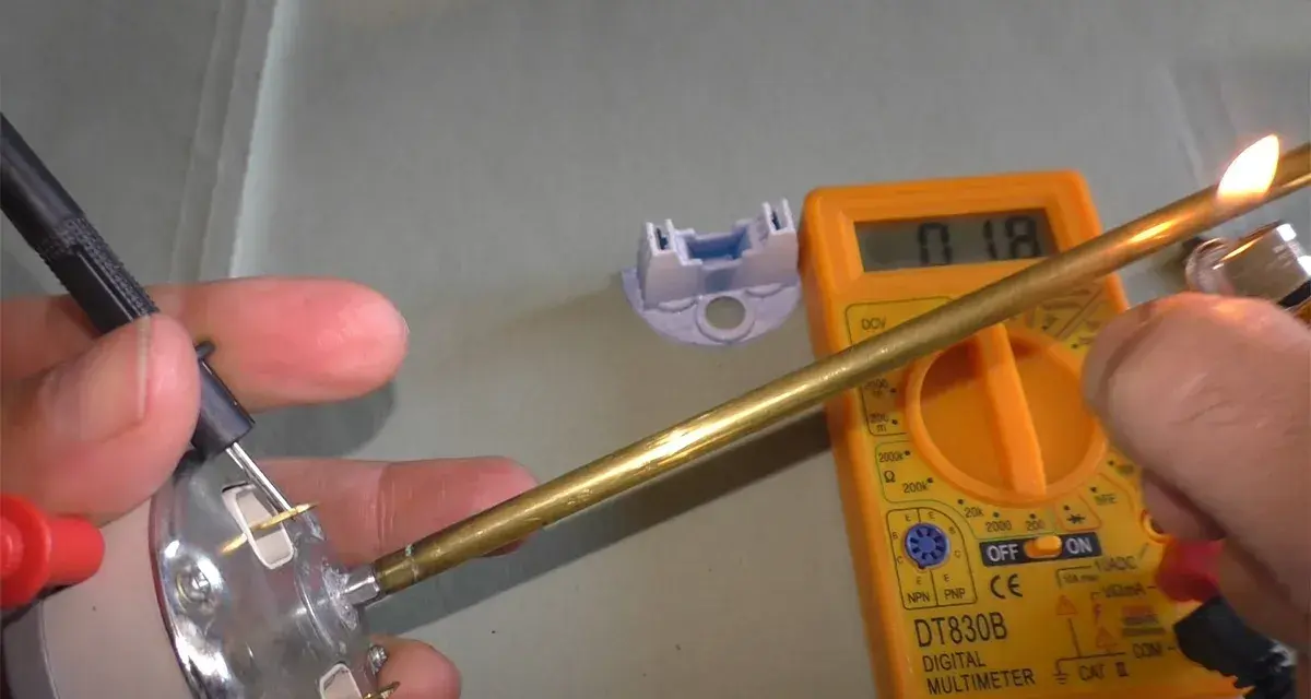 Come controllare un termostato con il tester: un multimetro digitale misura la resistenza di un componente metallico riscaldato.