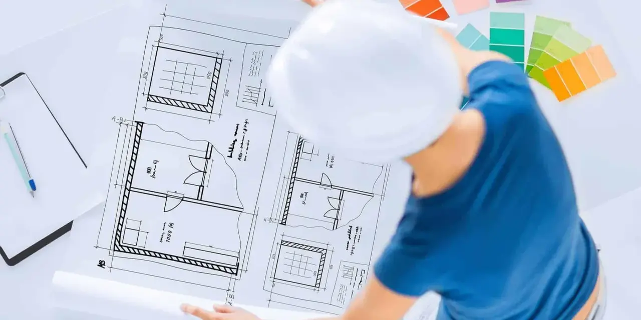 Pracownia znanych projektantów wnętrz: szkice planów, palety kolorów i biały kask.