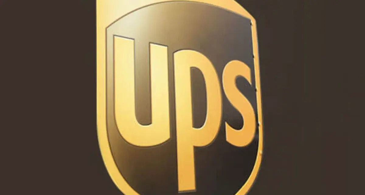 Logo UPS dorato su sfondo scuro. Informazioni sullo stipendio corriere UPS.