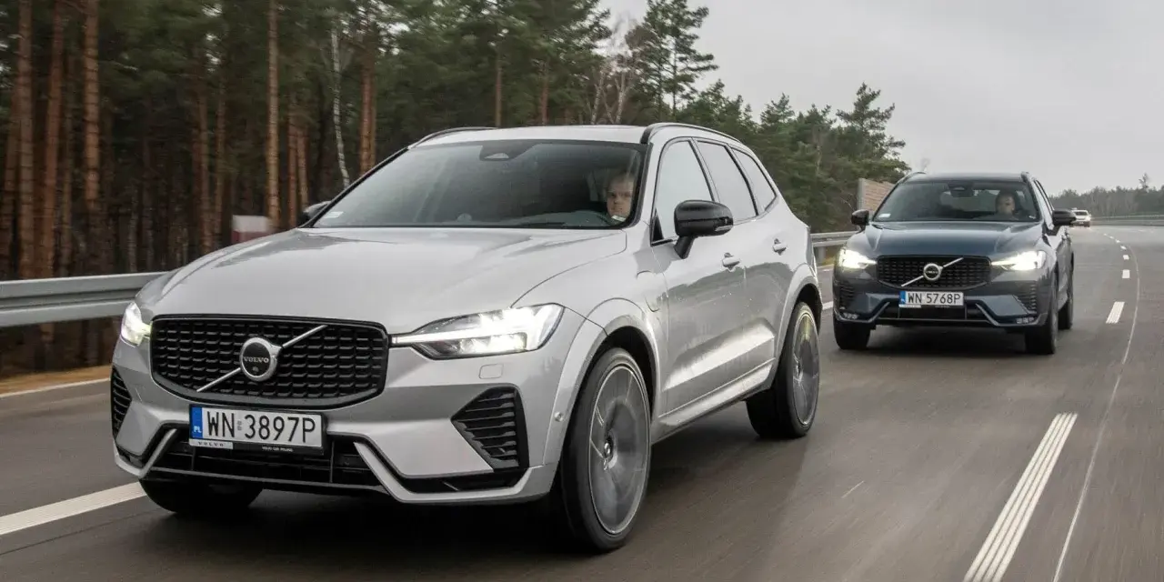 Dwa Volvo XC60 T8 jadące po drodze leśnej. Jeden srebrny, drugi ciemnoszary.