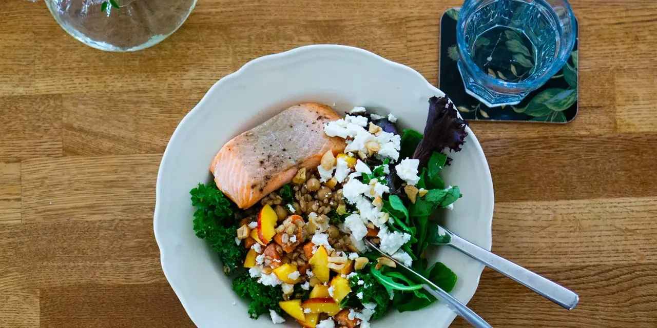 Laxskål med krispig grönkål, frukt, nötter och ost. En hälsosam måltid med 30g protein.