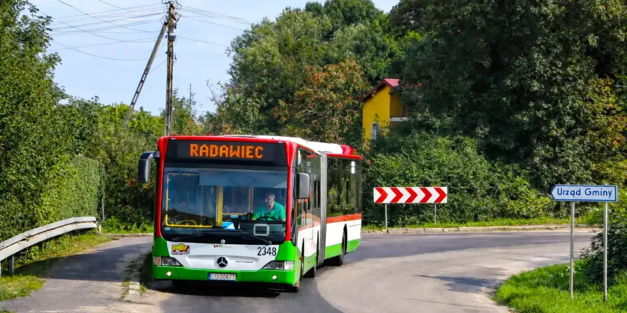 Autobus linii 43 jedzie do Radawca. Na drodze znak "Urząd Gminy".