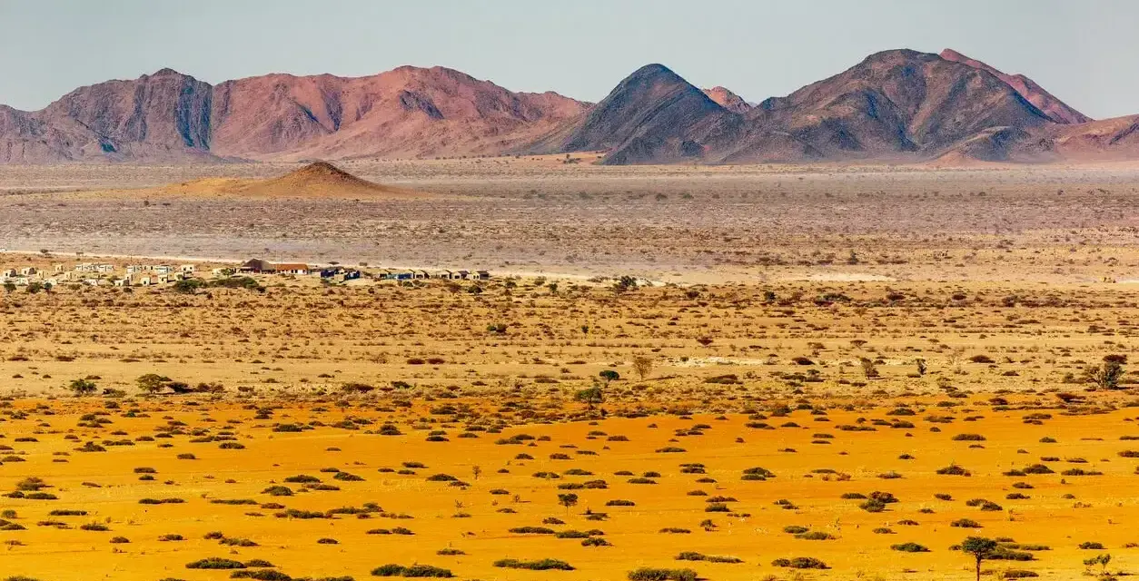 Pustynny krajobraz Namibii z górami w tle. Idealny czas na podróż do Namibii to okres od maja do października, kiedy jest sucho i chłodniej.