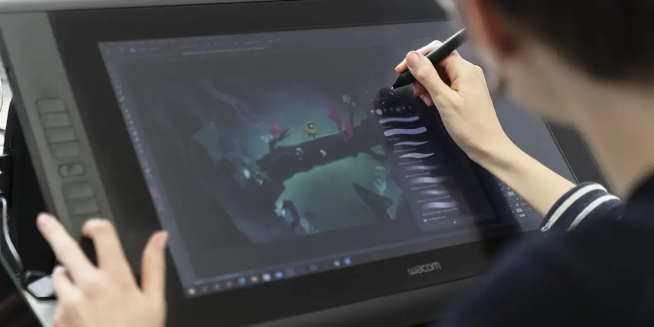 Person im Animation Studium nutzt Grafiktablett für digitale Kunst.