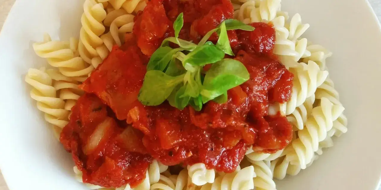 Fusilli z bogatym sosem passata pomidorowa, ozdobione świeżą zieleniną. Pyszne danie, które zadowoli każdego miłośnika włoskich smaków.