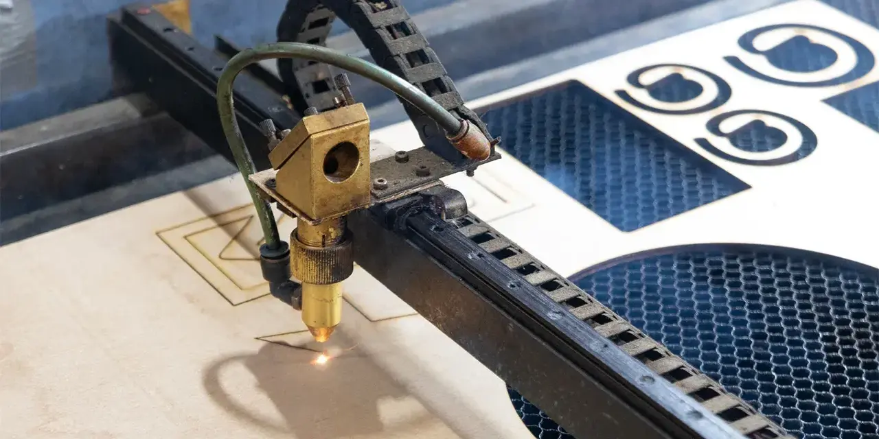 Macchina laser che sta per tagliare compensato, creando forme precise.
