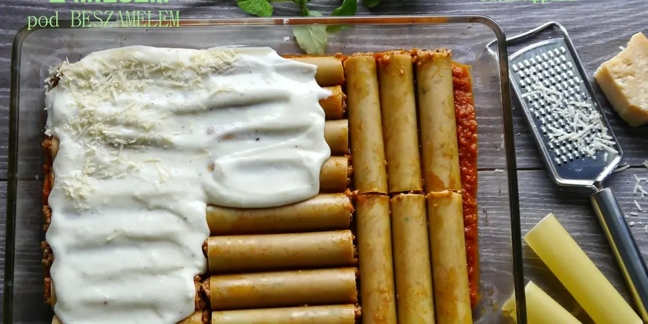 Cannelloni z mięsem mielonym i sosem beszamelowym w naczyniu żaroodpornym, gotowe do pieczenia. Obok tarka i kawałek parmezanu.