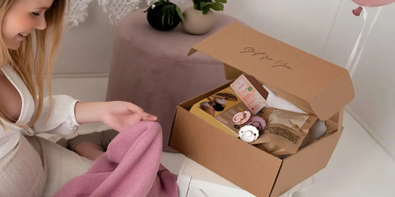 En blivande mamma inspekterar en presentkorg med nappar och hudvårdsprodukter.