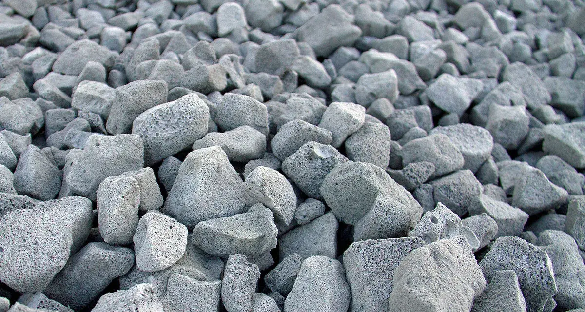 En stor hög med grå, porösa stenar. Skumglas nackdelar kan vara att materialet är lätt och kan blåsa iväg.
