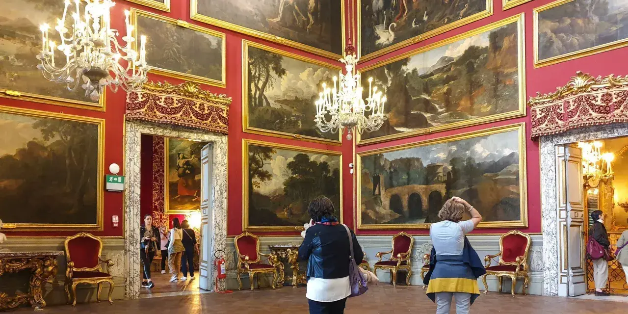 Wnętrze Galerii Doria Pamphilj z obrazami i żyrandolami.