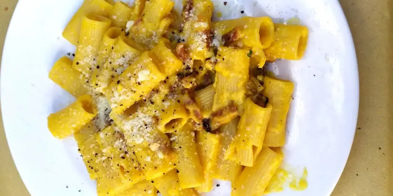 Macarrones con nata, cubiertos de queso rallado y pimienta negra, con trocitos de bacon crujiente.