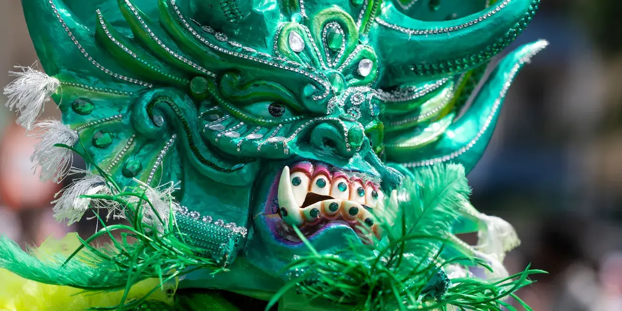 Grüne Maske mit funkelnden Steinen und Federn, ein Blickfang beim Carnival of Cultures Berlin.