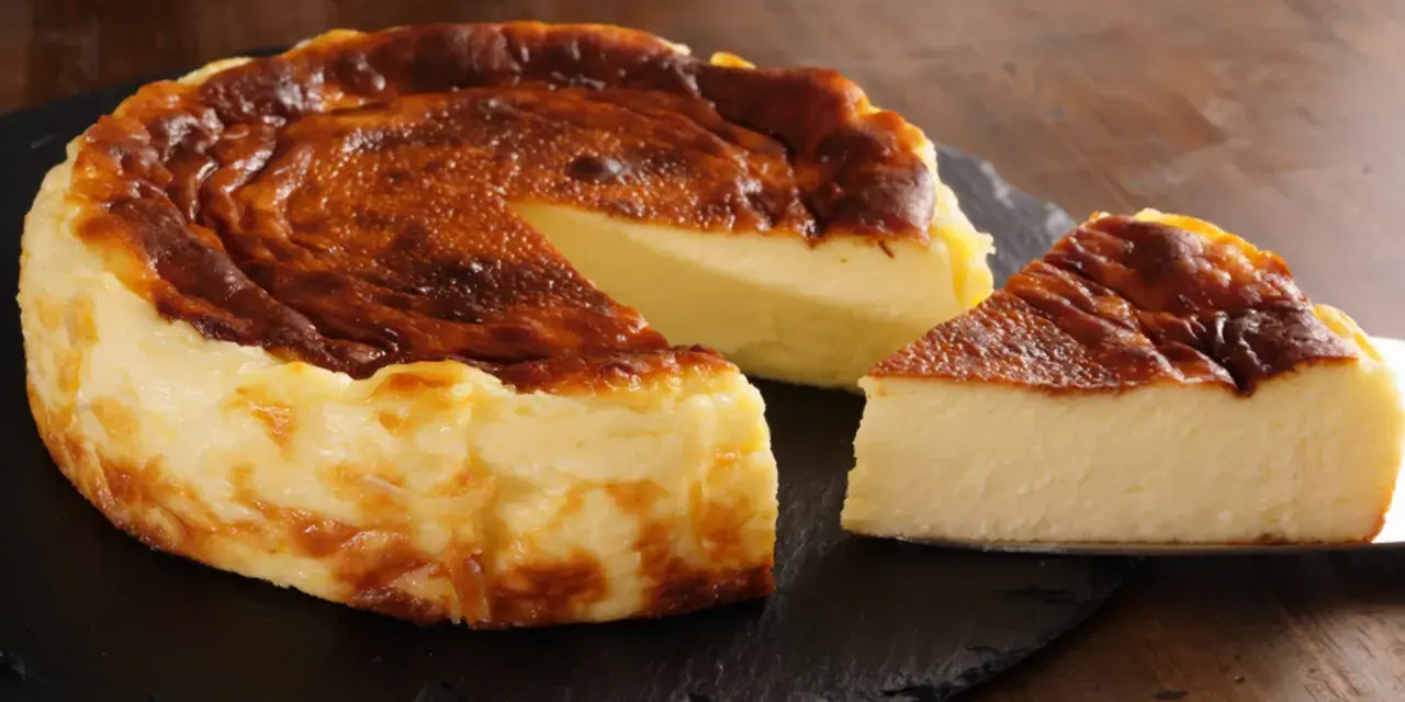 Pyszny, lekko przypieczony sernik na czarnej desce. Nawet jeśli sernik kcal kusi, warto spróbować!