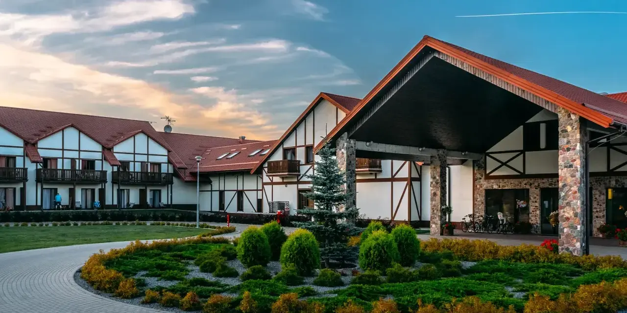 Elegancki hotel Mikołajki Spa z charakterystyczną architekturą i zadbanym ogrodem zaprasza na wypoczynek.