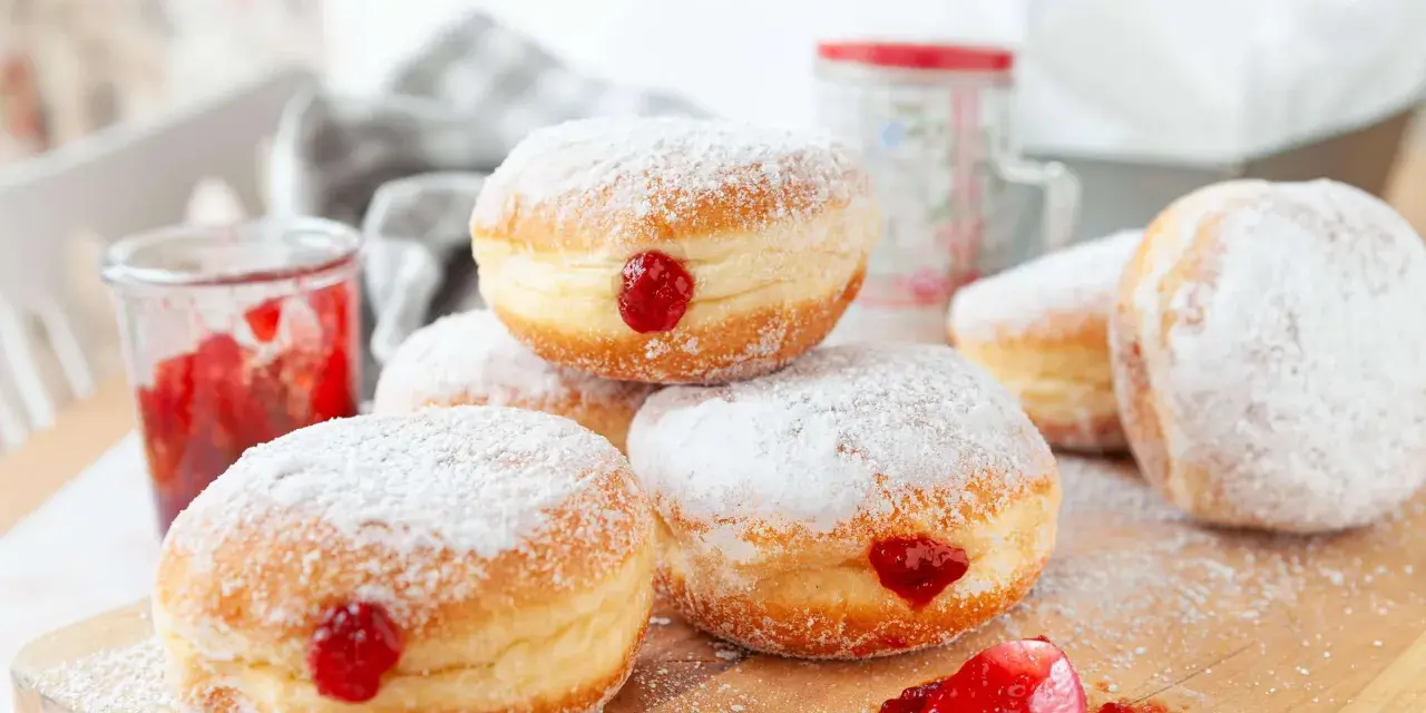 Frisch gebackene Krapfen im Airfryer, mit Puderzucker bestäubt und leckerer Marmelade gefüllt.