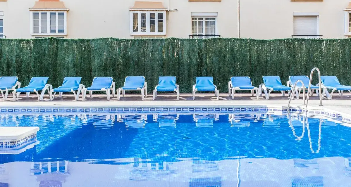 Błękitne morze przy hotelu Gran Cervantes, puste leżaki czekają na gości.