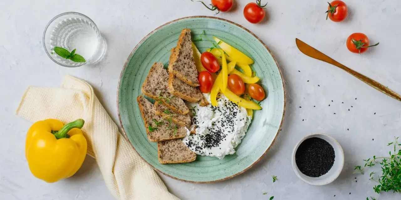 Talerz z twarogiem, pieczywem, pomidorkami i papryką. Idealne na śniadanie z serii dieta wysokobiałkowa przepisy.