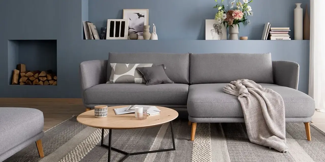 Gemütliches wohnzimmer skandinavischer stil mit grauem Sofa, Holztisch und Kamin.