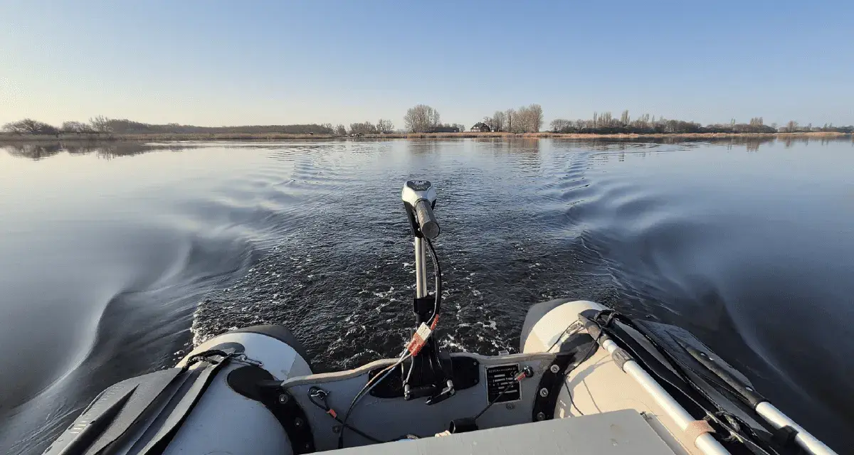 Schlauchboot mit Außenborder auf ruhigem Wasser. Die Beleuchtung des Schlauchboots entspricht der Vorschrift für sicheres Fahren.