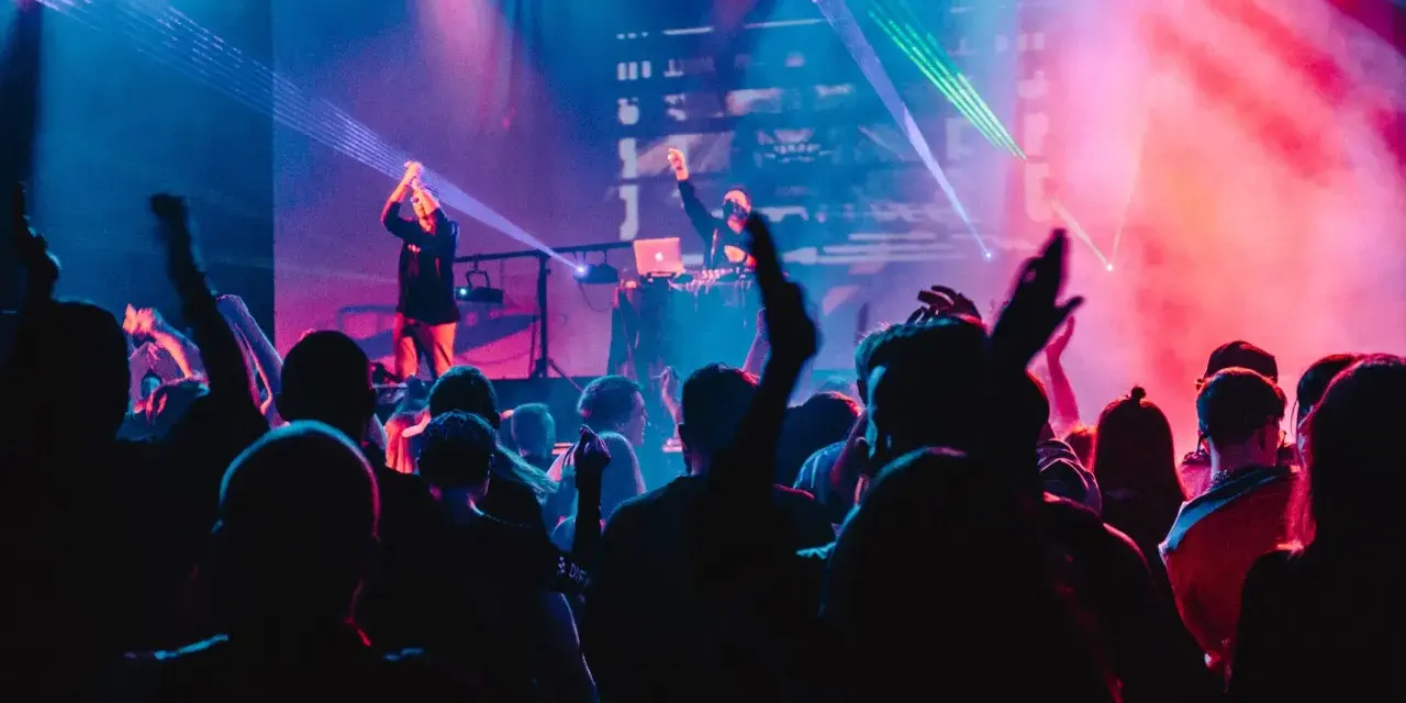 Eine Menge feiert zu A&R Music bei einem Konzert mit Lasershow.