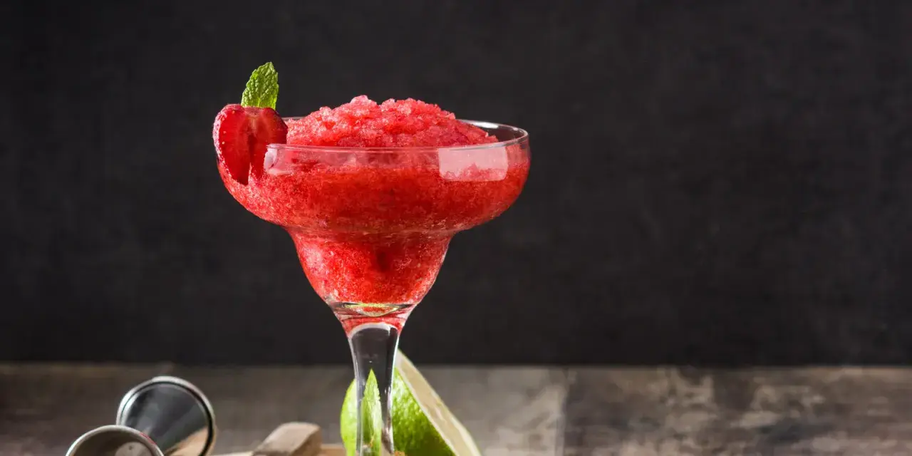 En fryst strawberry daiquiri med mynta och jordgubbsdekoration, redo att avnjutas.