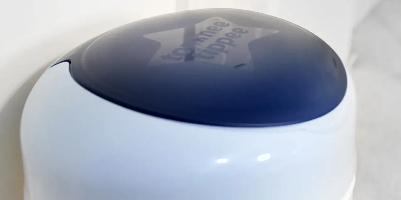 Niebieska pokrywa kosza na pampersy Tommee Tippee z wygrawerowanym logo.