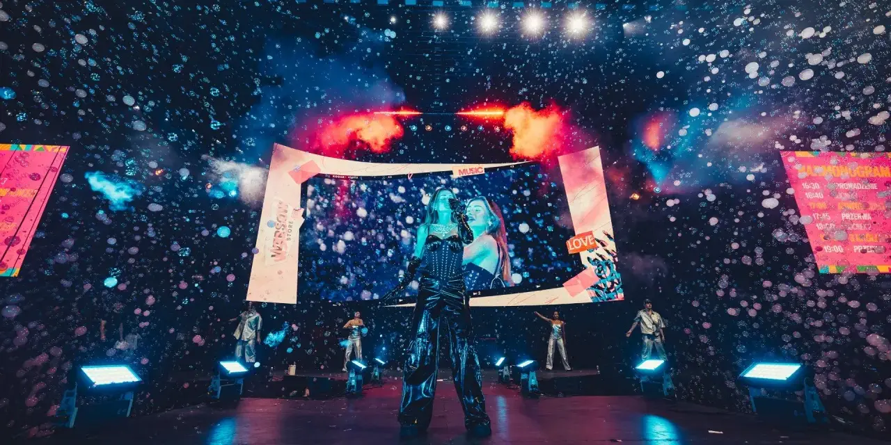 Wokalistka na scenie podczas festiwalu ekipy 2026, w otoczeniu baniek mydlanych i efektów świetlnych.