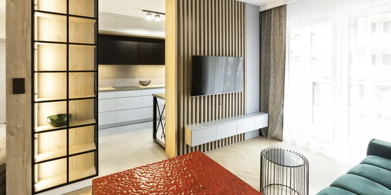 Nowoczesny, bardzo mały salon w bloku z otwartą kuchnią, drewnianymi panelami i designerskimi meblami.