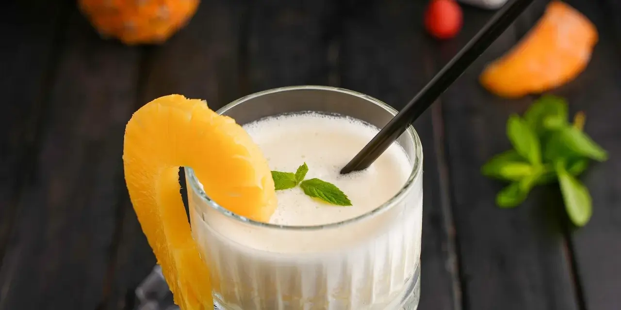 En krämig pina colada med ananasskiva och mynta. Perfekt för en solig dag.