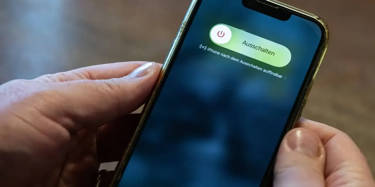 Hände halten ein iPhone mit dem Ausschaltmenü.