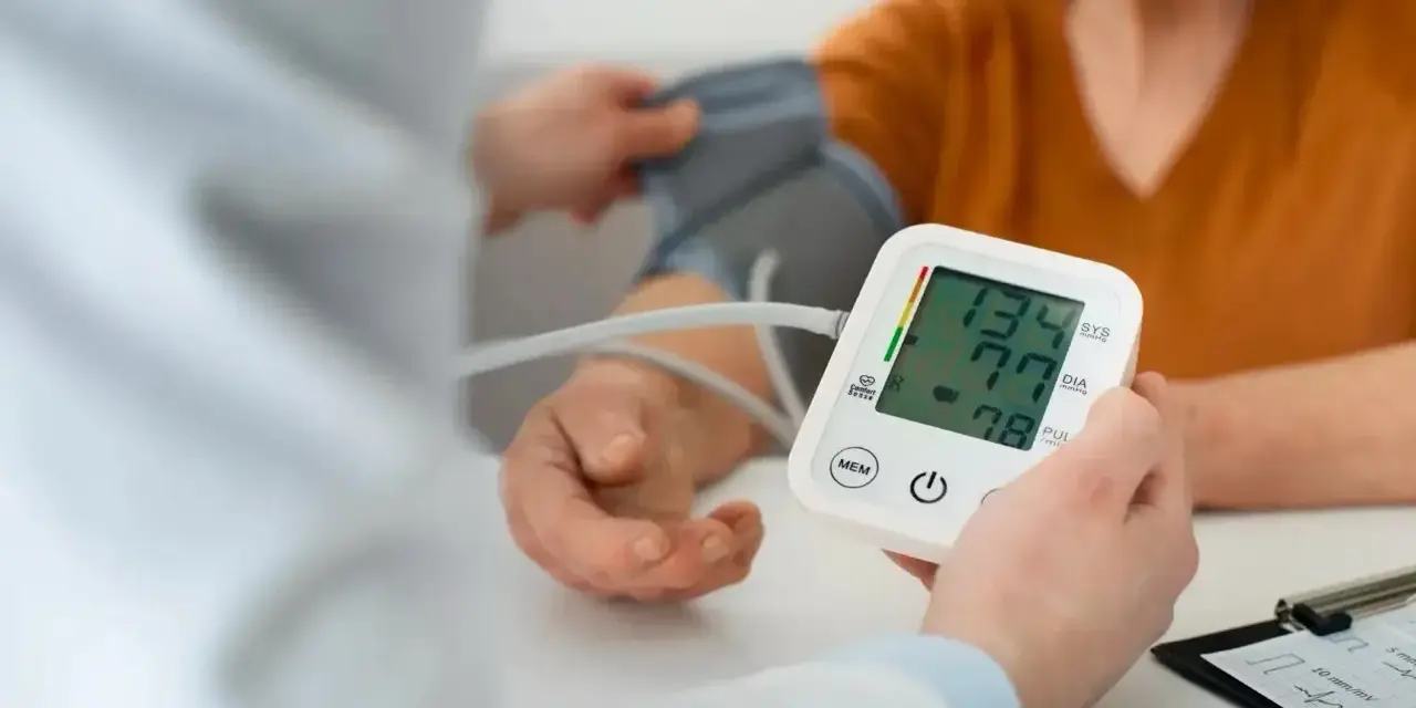 Pomiar ciśnienia krwi. Na ekranie aparatu widnieje wynik 134/77, a poniżej 78.