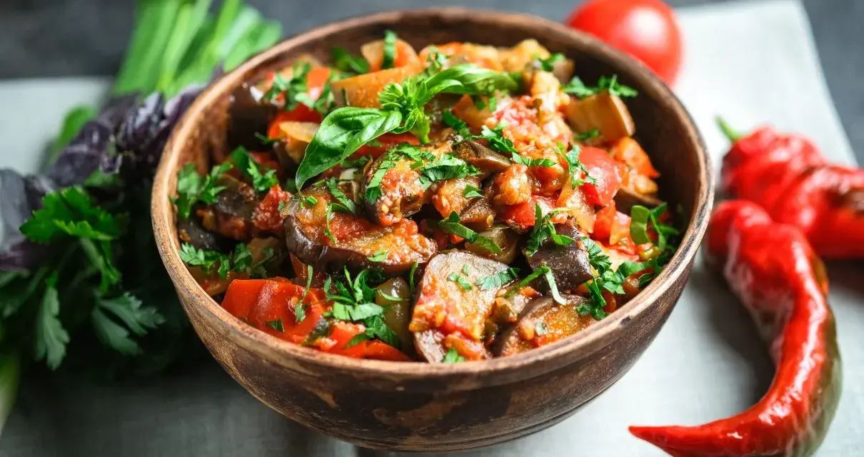 Caponata co to? Aromatyczne, sycylijskie danie z bakłażana, pomidorów i papryki, posypane świeżą pietruszką.