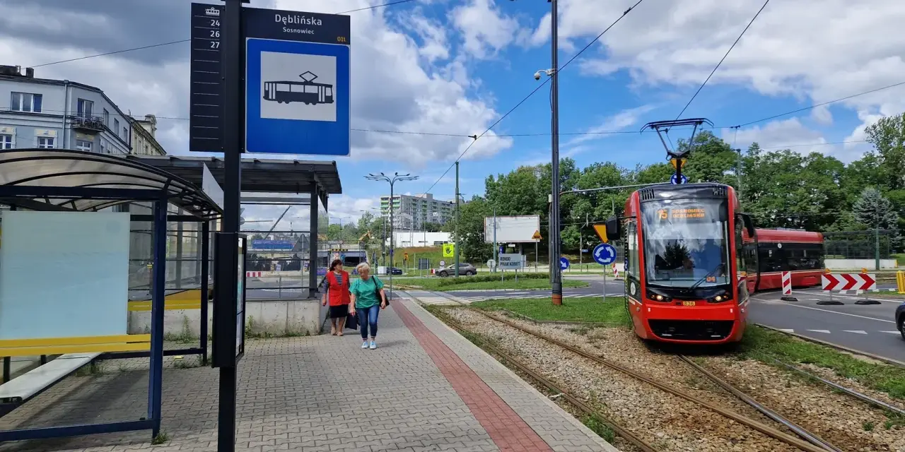Przystanek Dęblińska w Sosnowcu. Tramwaj czeka na pasażerów, a rozkład jazdy MZK jest widoczny na słupie.
