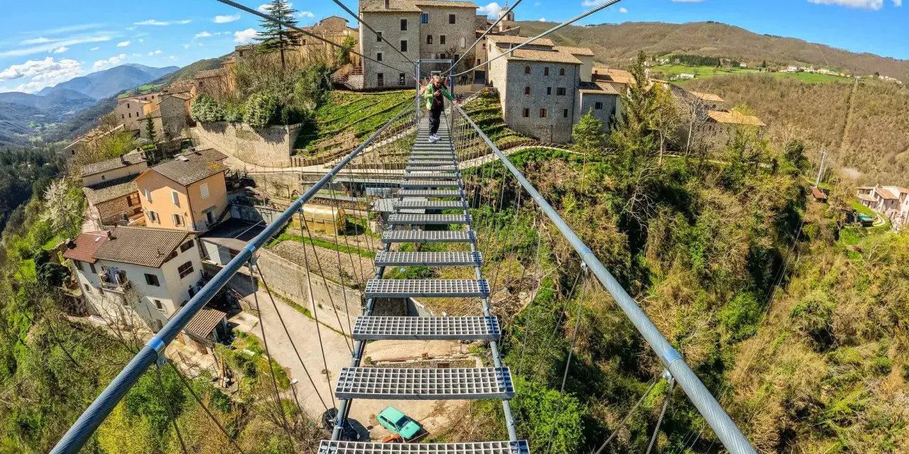 Ponte tibetano sellano, una passerella sospesa che collega borghi antichi, offre una vista mozzafiato sulla valle. La sua lunghezza è un'avventura.