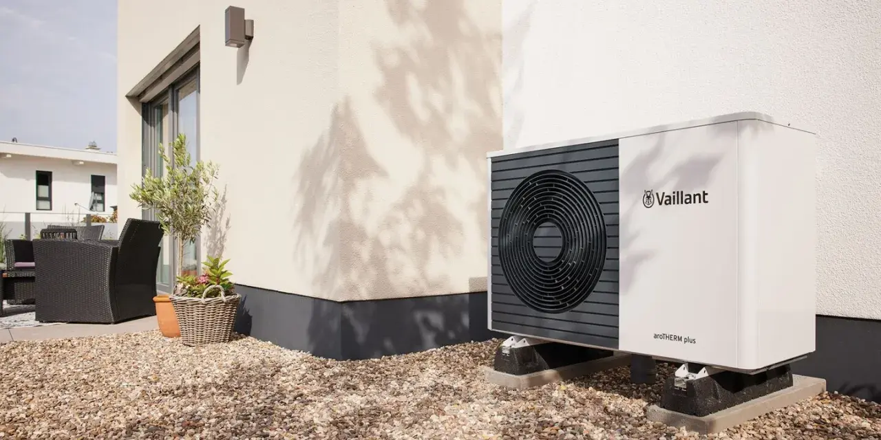 Unità esterna Vaillant per raffrescamento con termosifoni, posizionata su ghiaia vicino a una casa moderna.