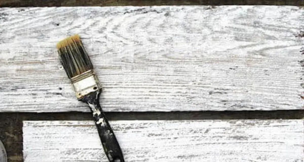 Pennello sporco su assi di legno bianco, pronto per la cementite per legno già verniciato.