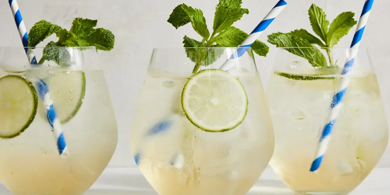 Tre svalkande Hugo Spritz med mynta och lime, perfekta för en solig dag.