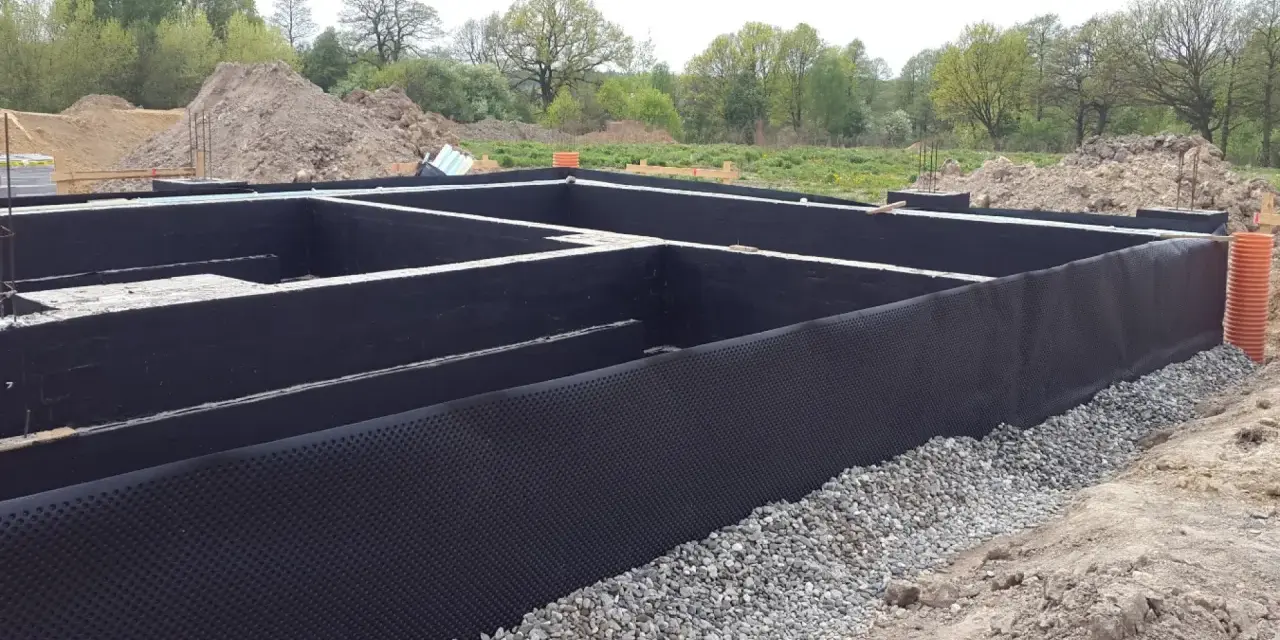 Fundament gotowy do zalania betonem. Czarna folia izolacja pozioma chroni przed wilgocią.
