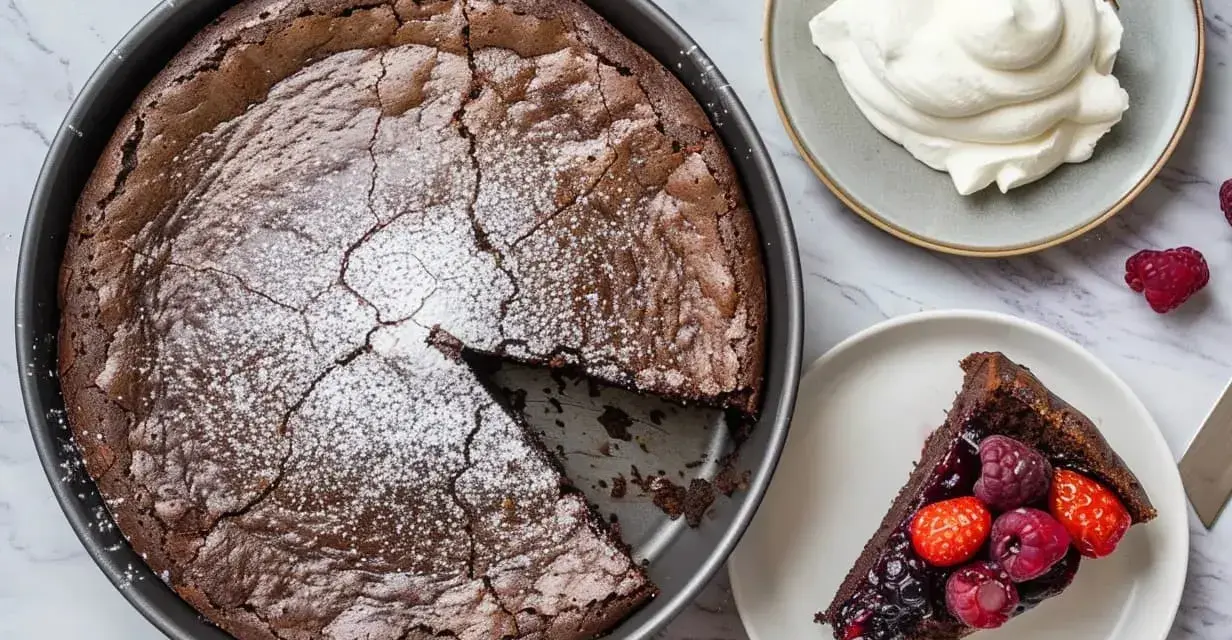 En saftig snabb kladdkaka i form, pudrad med florsocker. En bit serveras med bär och vispgrädde.
