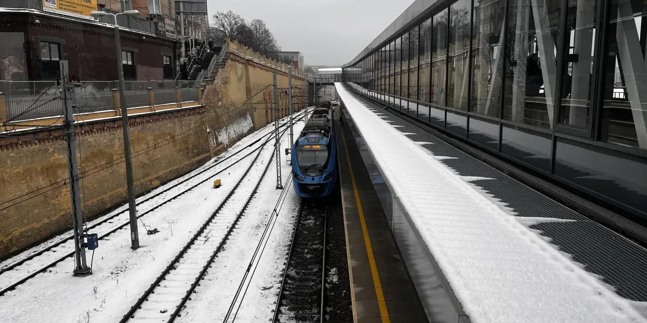 Zimowy dzień na stacji Warszawa Wschodnia. Pociąg IC OSTERWA stoi na torach, a peron pokrywa śnieg.