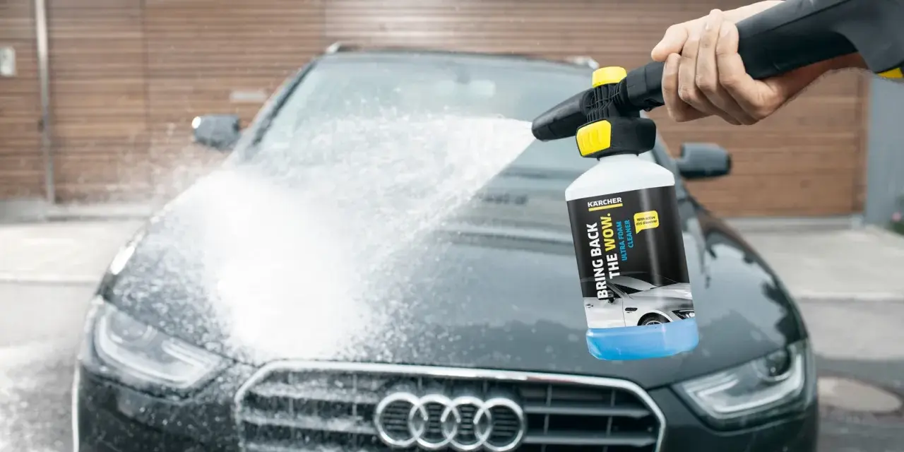 En hand sprutar Kärcher skum på en mörk Audi. Bilen får en djuprengöring med hjälp av Kärcher Ultra Foam Cleaner.