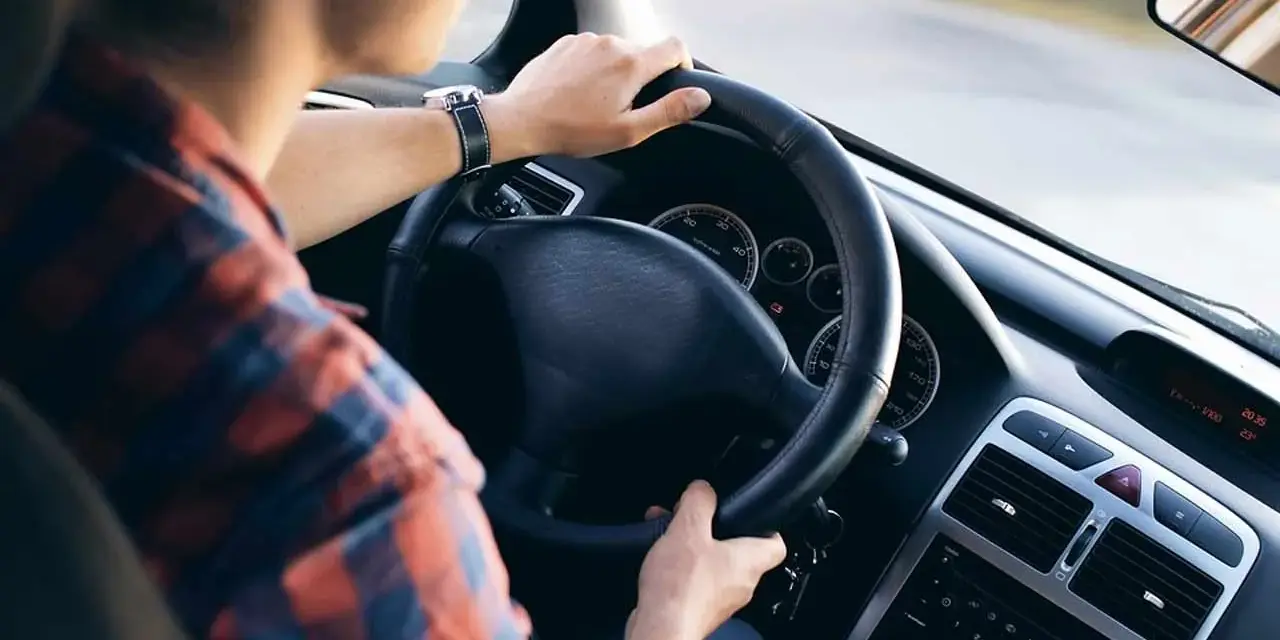 Uomo al volante, con le mani sul volante. Il servosterzo sembra duro, rendendo la guida più faticosa.