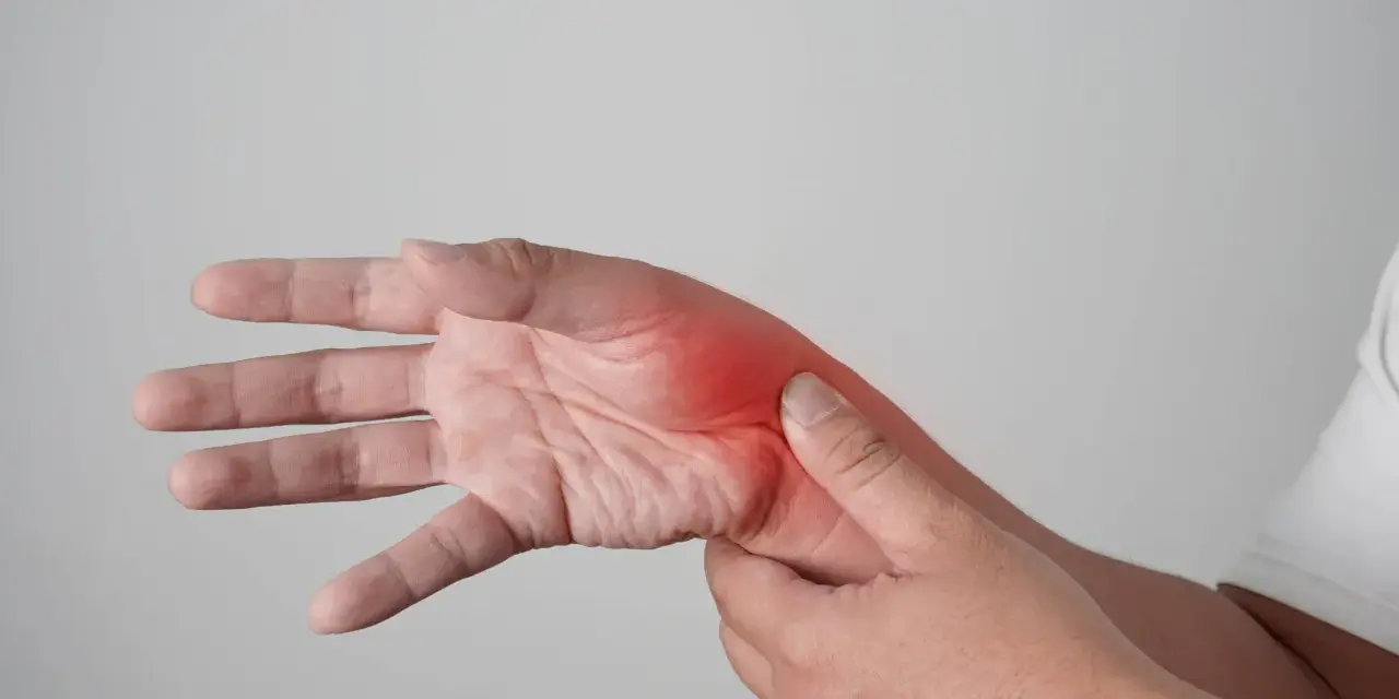 Main douloureuse, avec une zone rouge vif indiquant une possible fracture de fatigue main.