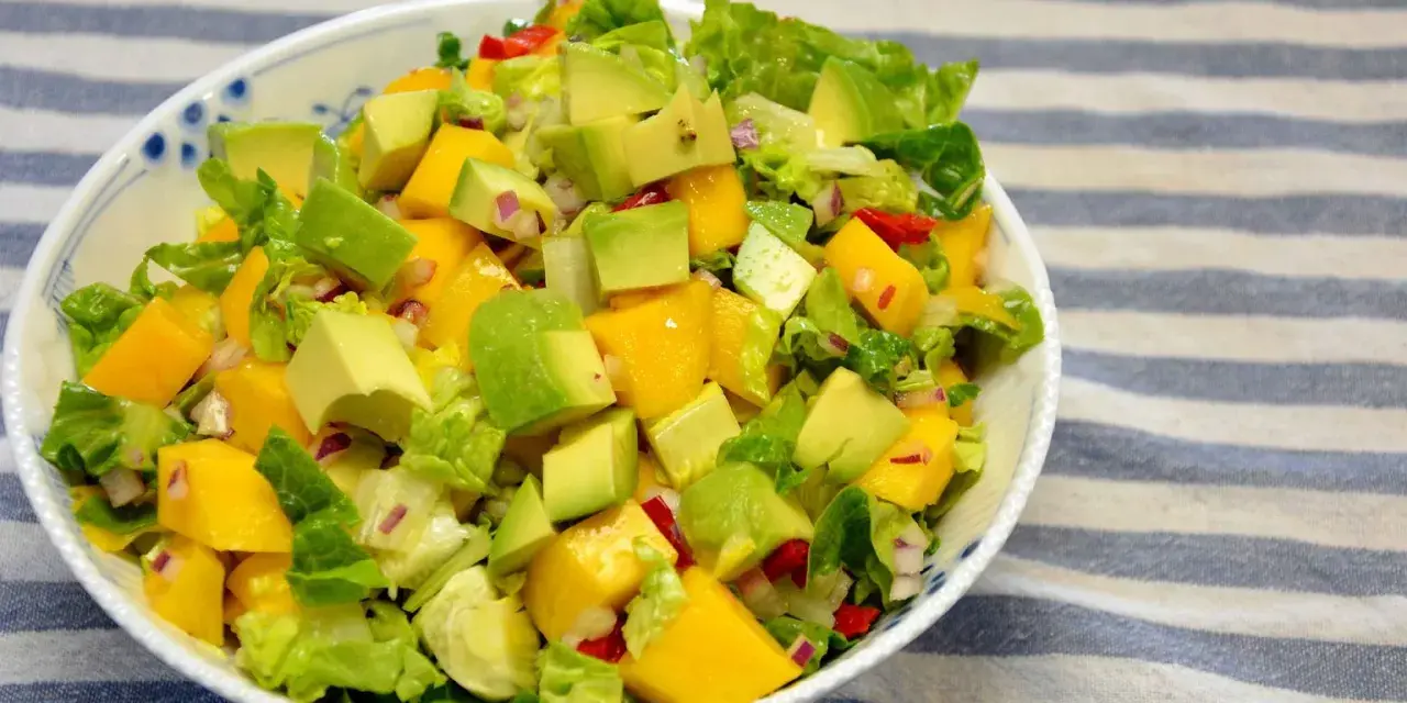 Orzeźwiająca sałatka z awokado, mango i czerwoną cebulą, polana lekkim sosem mango do sałatki.