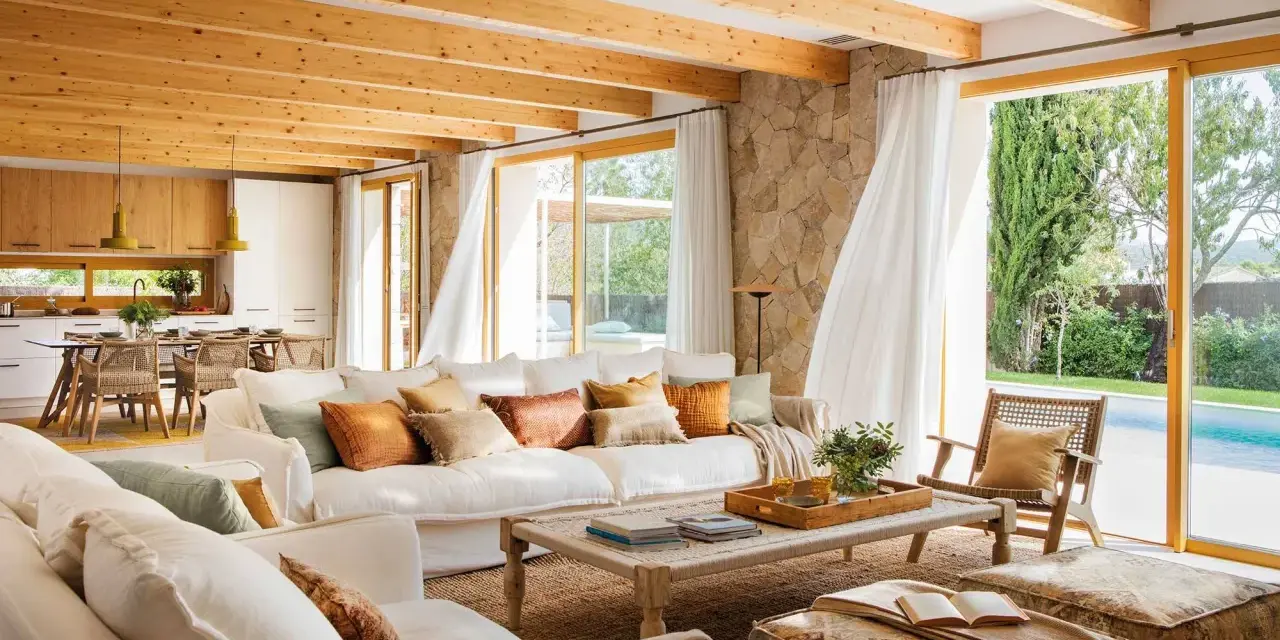 Salones de casas modernas con techos de madera, sofás blancos y vistas a una piscina.