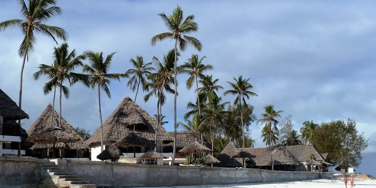Rajskie plaże Zanzibaru, palmy i domki z krytymi strzechą dachami. Przed wyjazdem warto pomyśleć o zanzibar szczepienia.