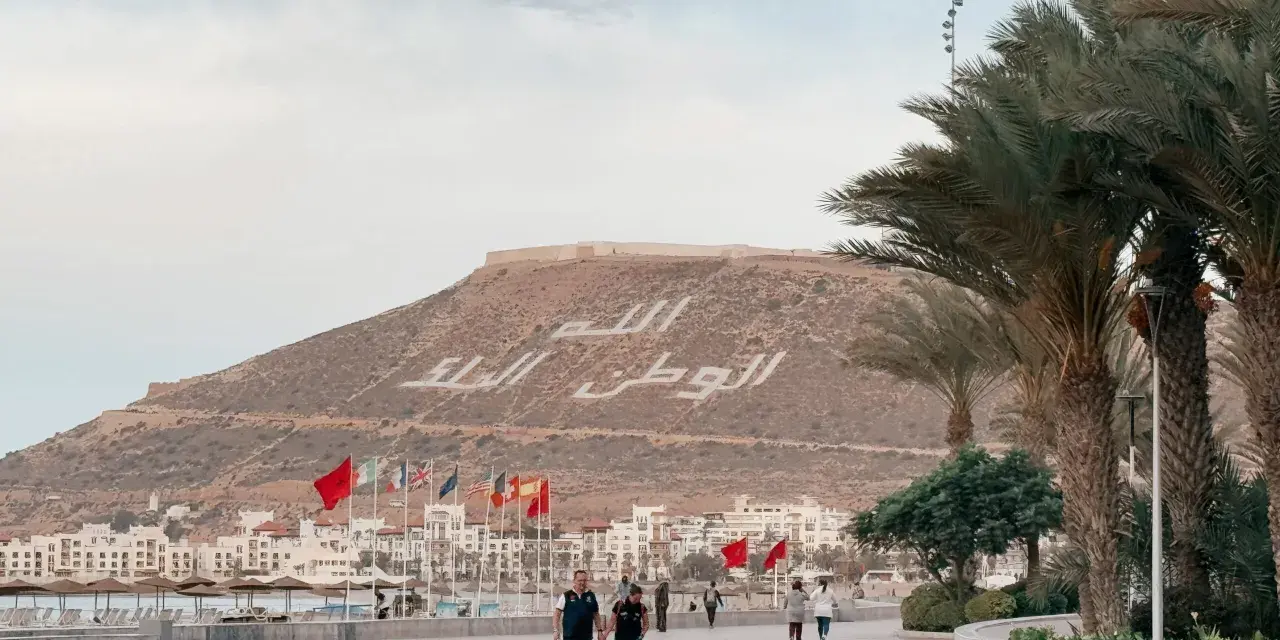 Spacerem po promenadzie w Agadirze, z widokiem na miasto i napisem na wzgórzu. Czy Agadir jest bezpieczny? Tak, wygląda na spokojne miejsce.