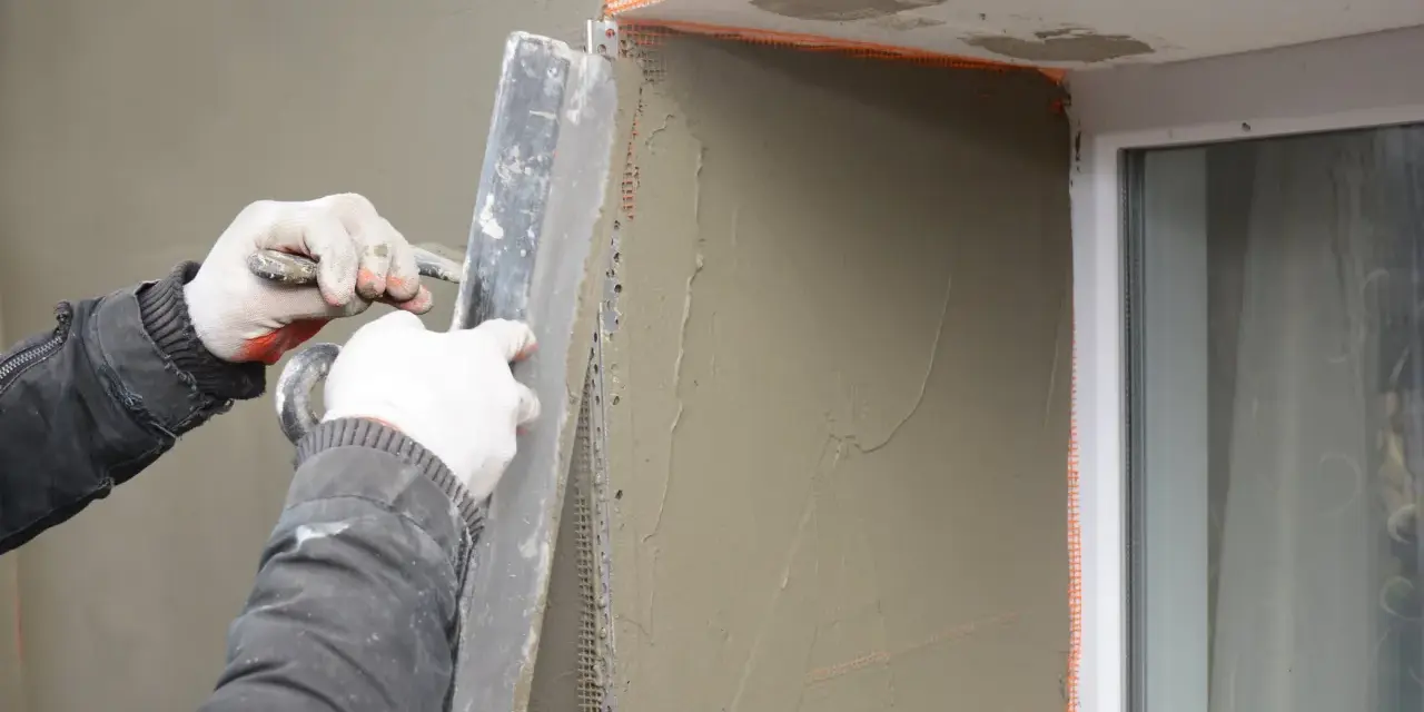 Lavori di intonacatura attorno alle finestre, con un cappotto che protegge le spallette. Si nota lo spessore dello strato di intonaco.