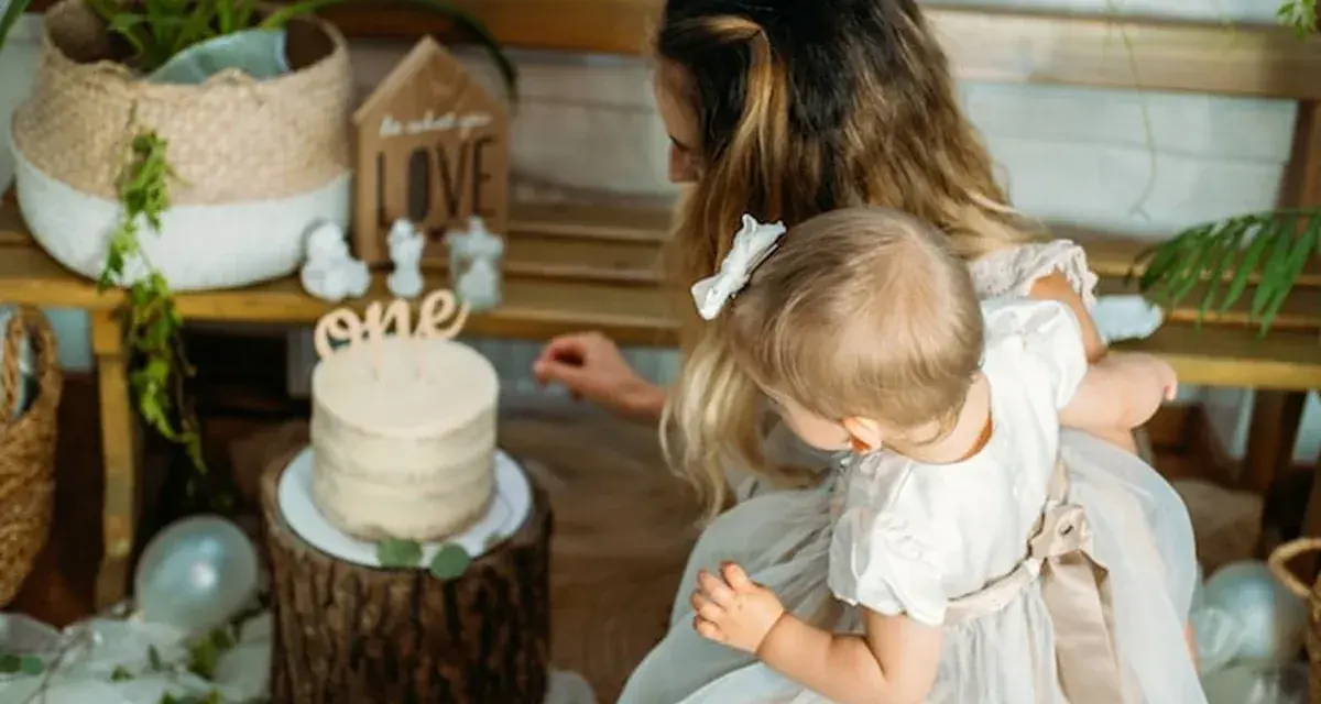 Mama z córką przy torcie na roczek. Piękny tort i dekoracje, idealne na prezent, co kladzie sie dziecku do wyboru na roczek.
